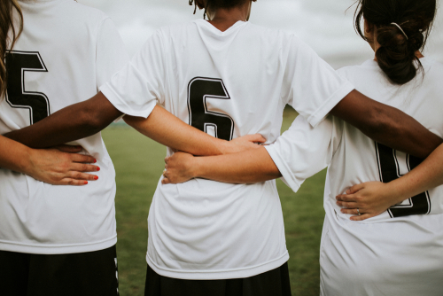 Female,Soccer,Players,Huddling,And,Standing,Together